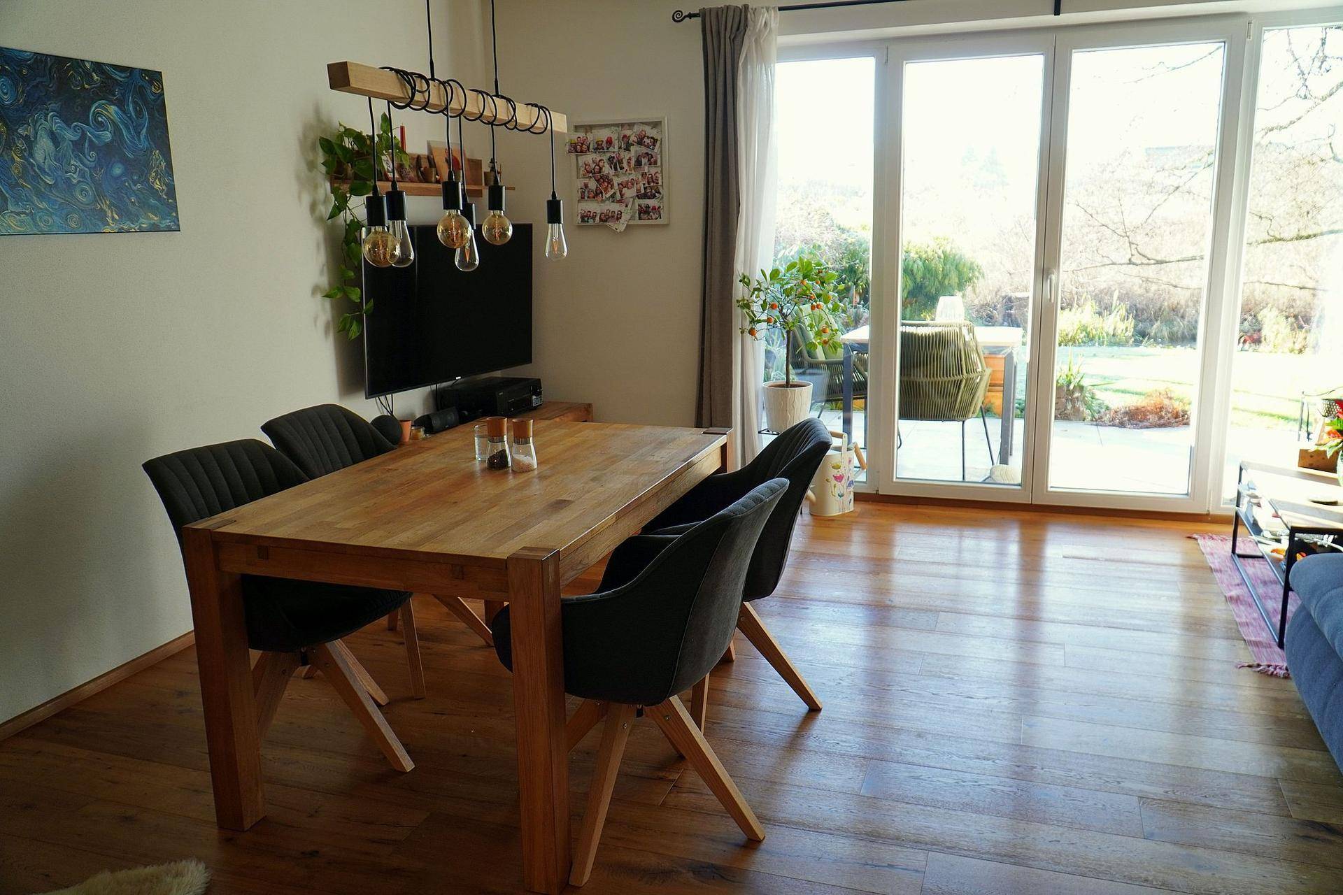 Heller Essbereich mit Holztisch, modernen Stühlen und Zugang zur Terrasse.