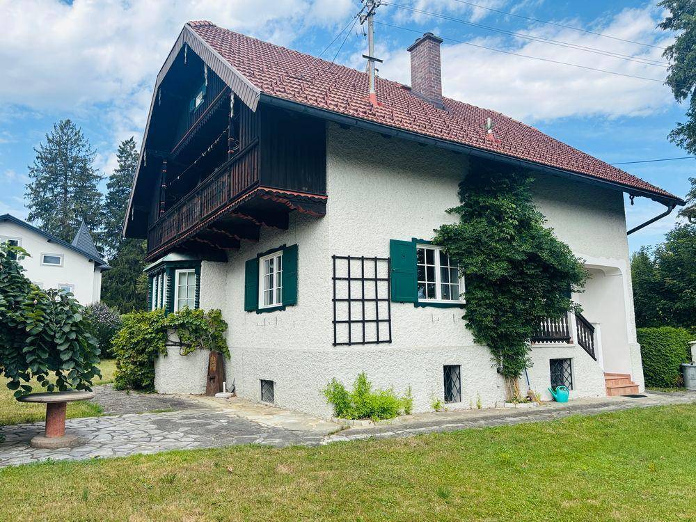 Charmantes Haus mit traditioneller Architektur, rotem Ziegeldach und gepflegtem Gartenbereich.