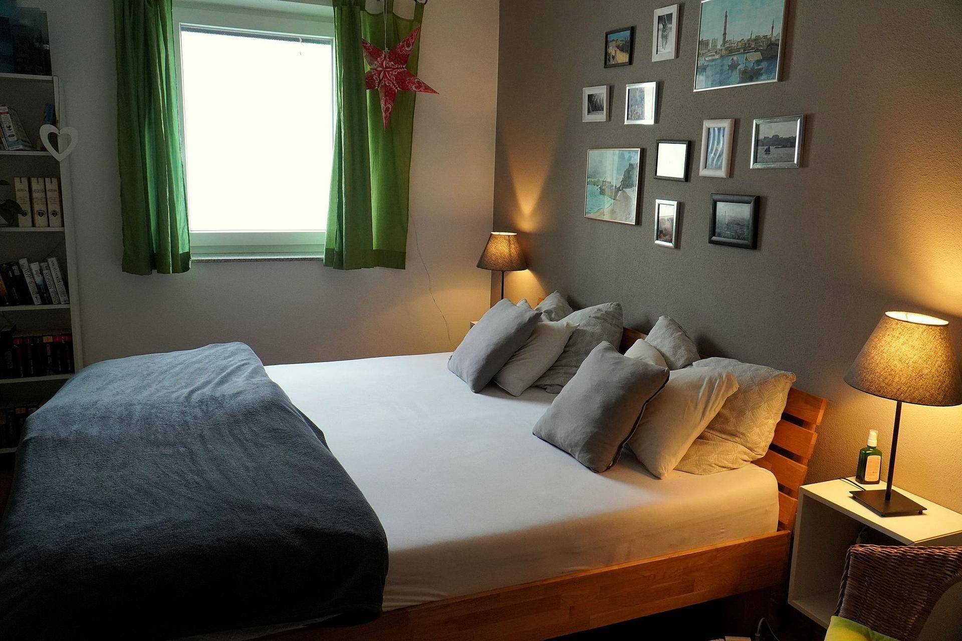 Gemütliches Schlafzimmer mit Doppelbett, Nachttischen und dekorativer Bilderwand.