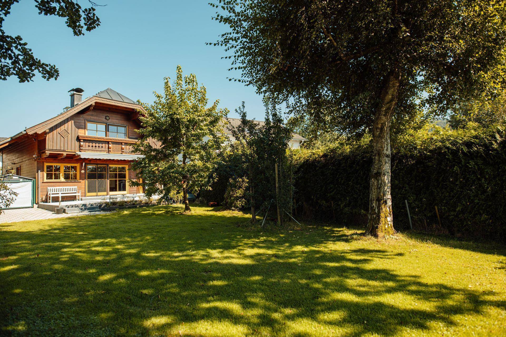 Großzügiger Garten mit gepflegtem Rasen und Blick auf das traditionelle Holzhaus.