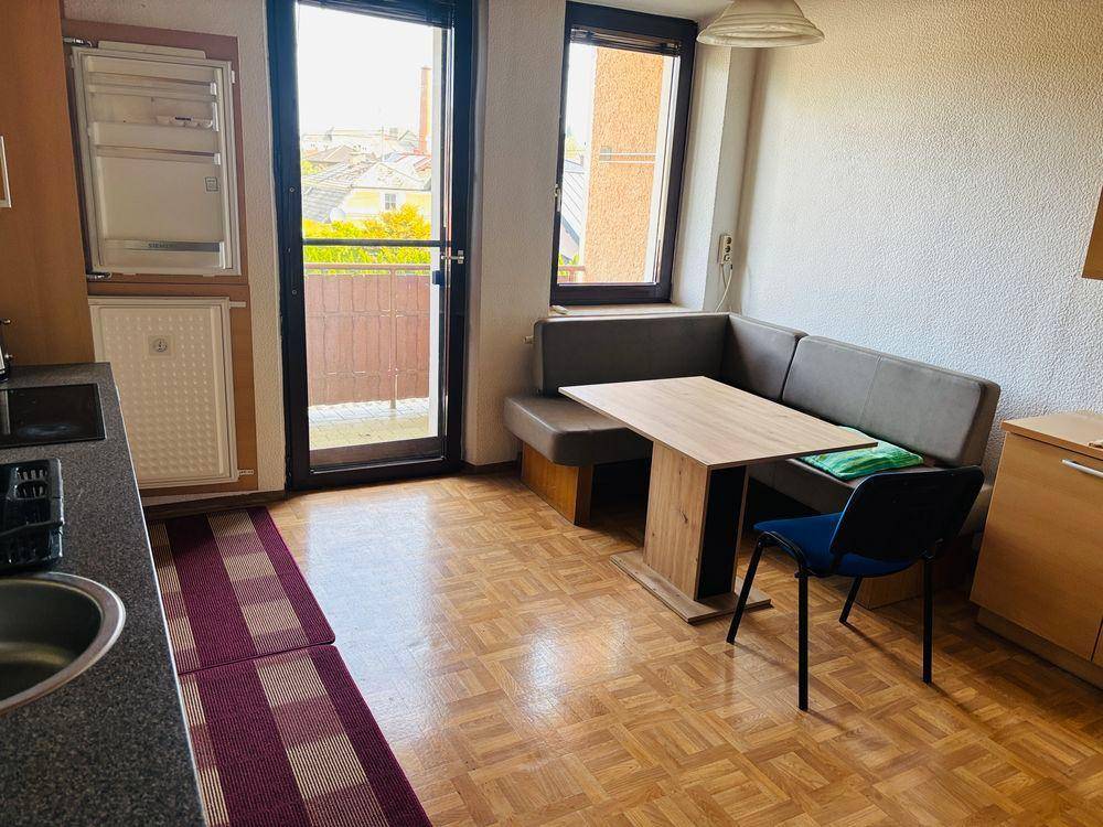 Heller Essbereich in der Küche mit gemütlicher Eckbank und Zugang zum Balkon.