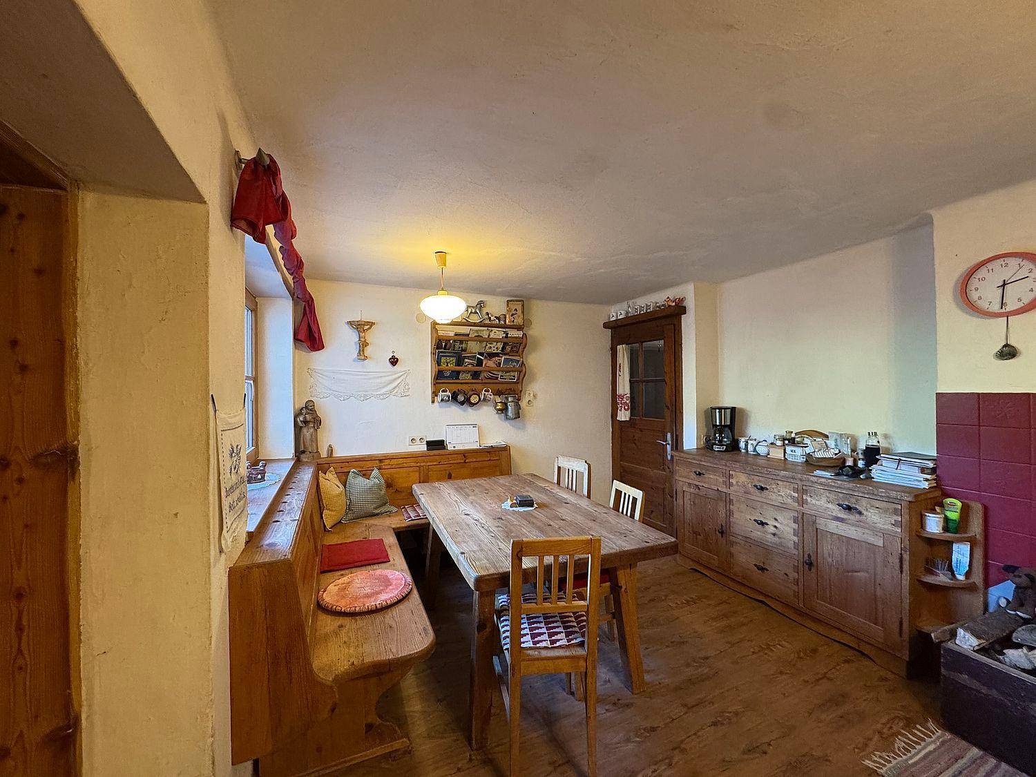 Gemütlicher Essbereich mit Holztisch, Eckbank und traditionellen Holzmöbeln.