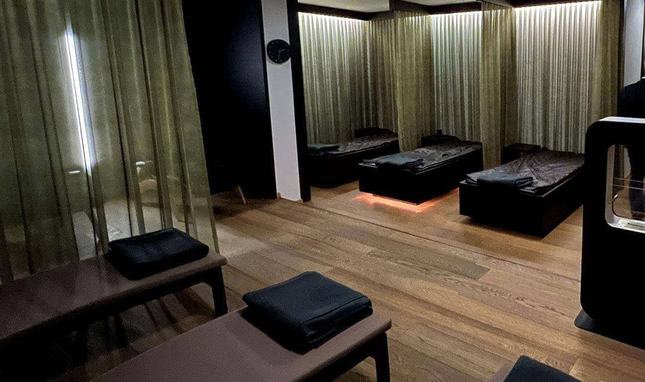 Ruhiger Ruheraum im Wellnessbereich mit bequemen Liegen und Holzboden für Entspannung.