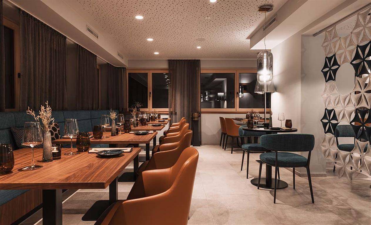 Elegantes Restaurant mit Holztischen, bequemen Sitzbänken und stilvoller Dekoration.