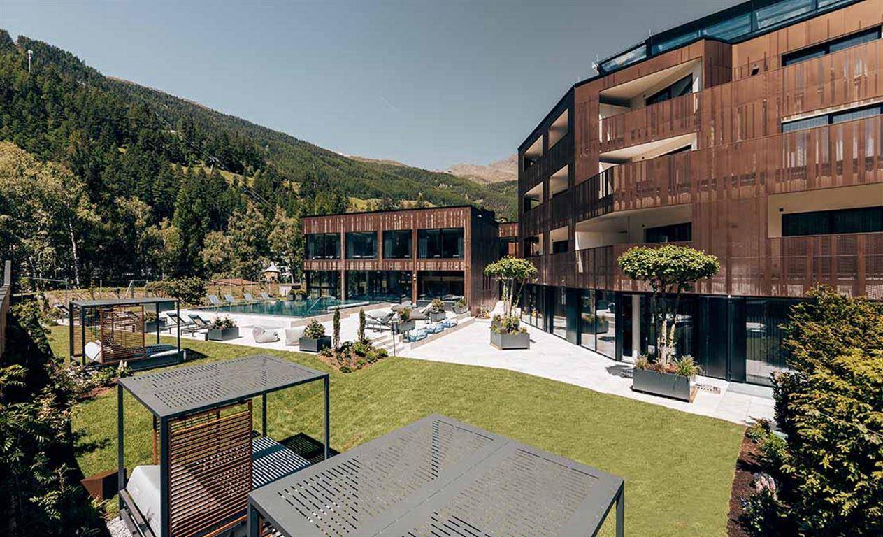 Gepflegter Gartenbereich mit modernen Sitzgelegenheiten und Blick auf das luxuriöse Gebäude.