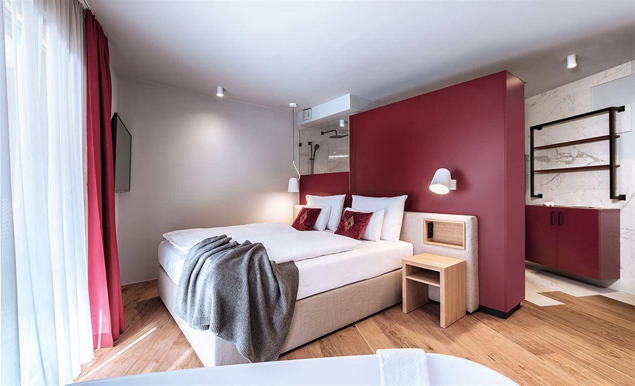 Geräumiges Schlafzimmer mit integriertem Badbereich und moderner Einrichtung.