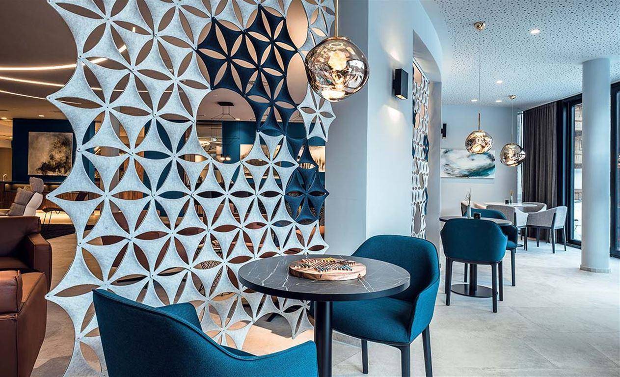 Moderner Lounge-Bereich mit dekorativen Trennwänden und bequemen Sitzgelegenheiten.