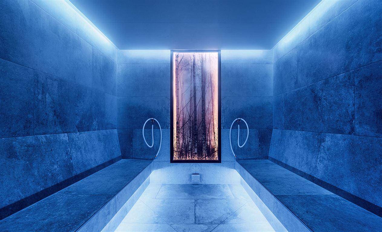 Modernes Dampfbad mit blauer Beleuchtung und stilvoller Wandgestaltung für Entspannung.