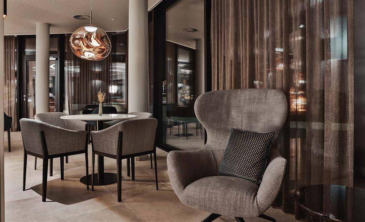 Gemütlicher Sitzbereich in der Lounge mit eleganten Sesseln und einem kleinen Tisch.