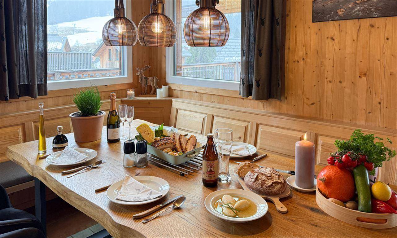 Einladender Essbereich mit Holztisch und Eckbank, festlich gedeckt für eine Mahlzeit.