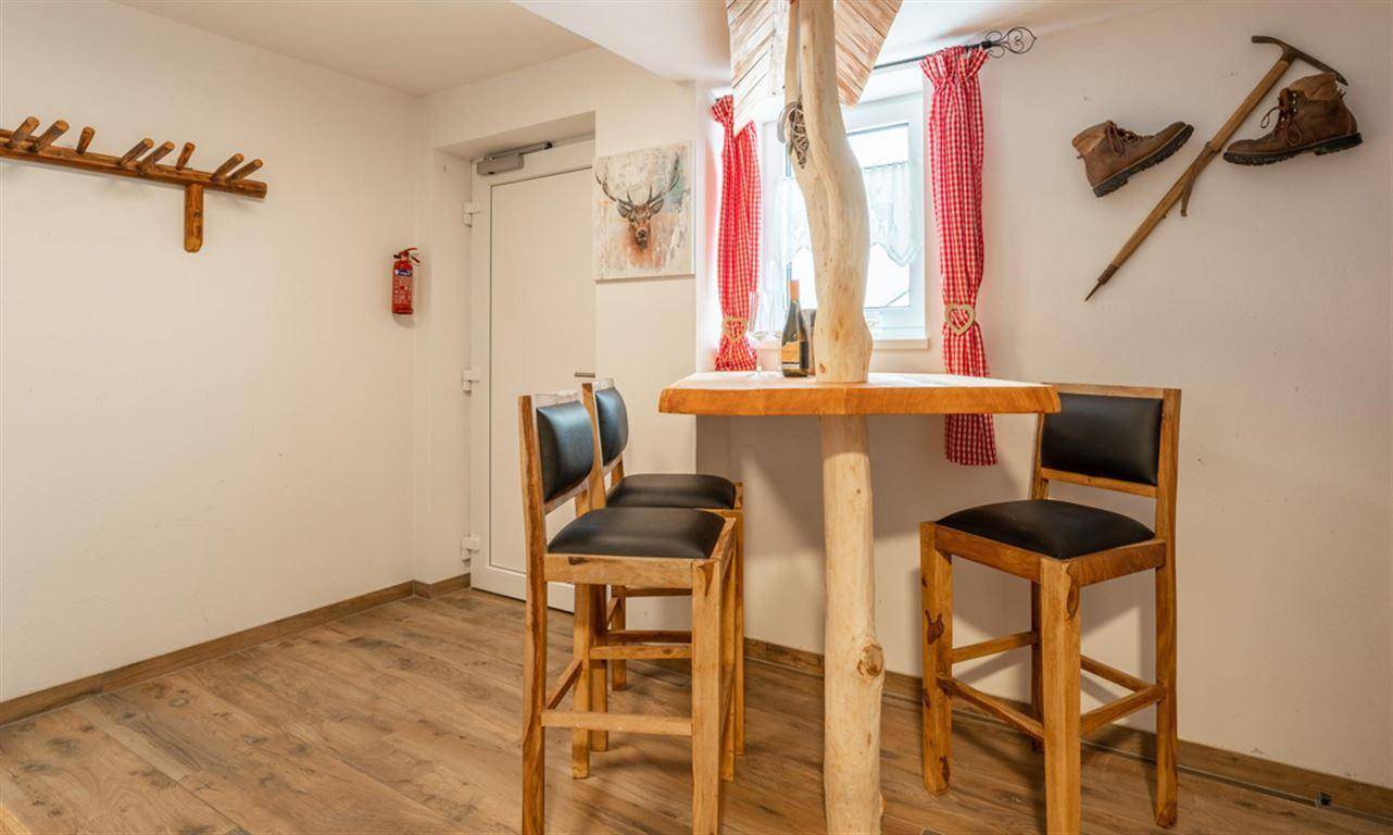 Rustikaler Innenraum mit Bartisch aus Holz und traditioneller Dekoration.