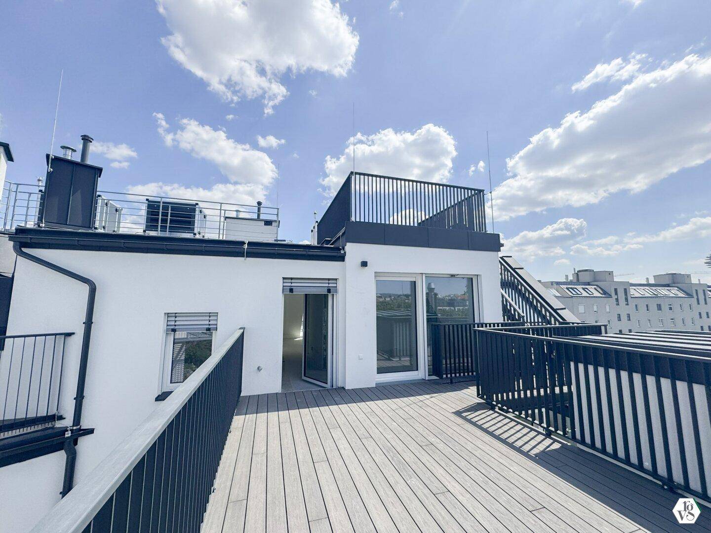 Zugang zur modernen Dachterrasse mit dunklem Geländer und weitem Blick über die Dächer der Stadt.