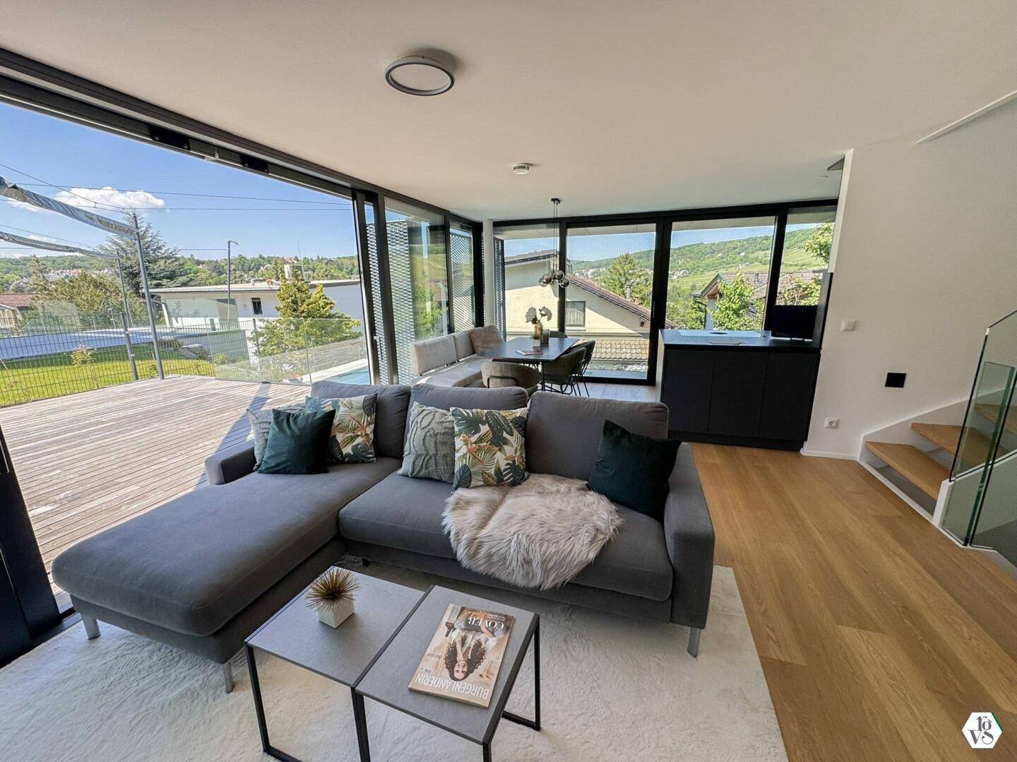Geräumiger Wohn-Essbereich mit modernem Sofa, Esstisch und Panoramablick ins Grüne.