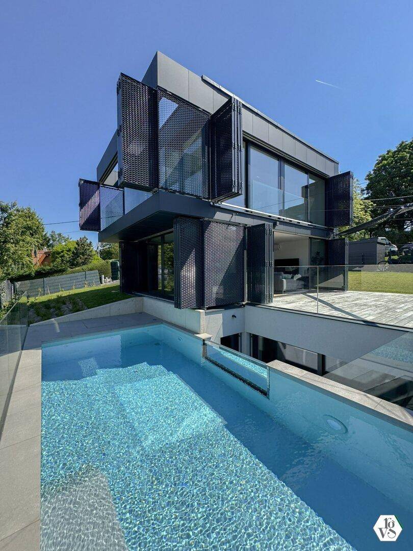Außenansicht eines modernen Gebäudes mit integriertem Pool und minimalistischem Design.