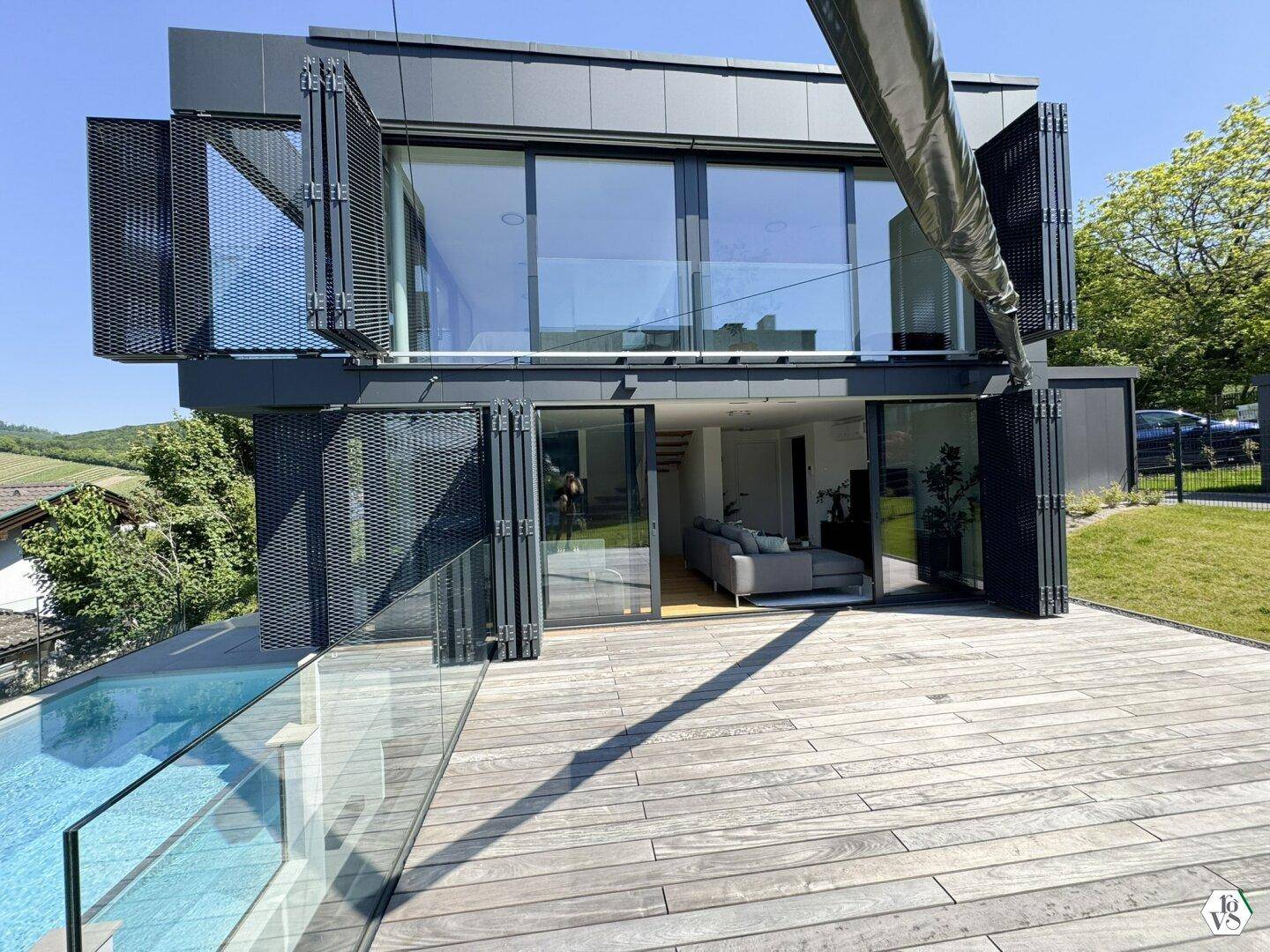 Moderne Architektur mit Holzterrasse und angrenzendem Poolbereich.