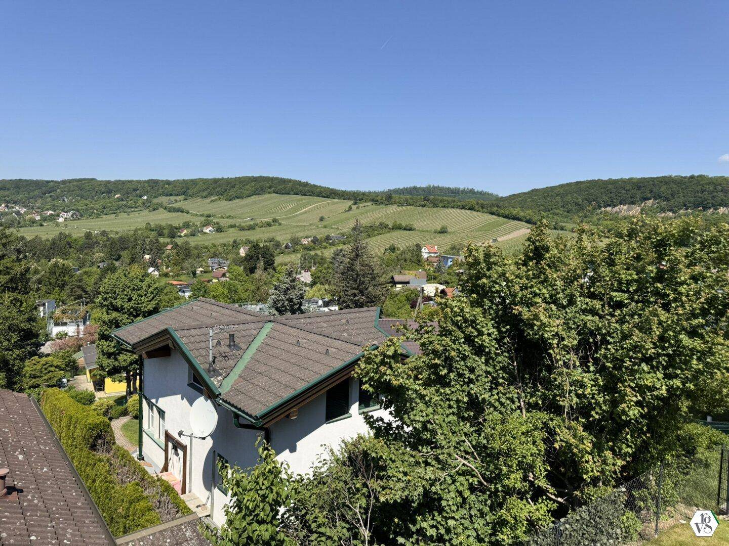 Weitläufiger Blick über grüne Hügel, Weinberge und die umliegende ländliche Gegend.