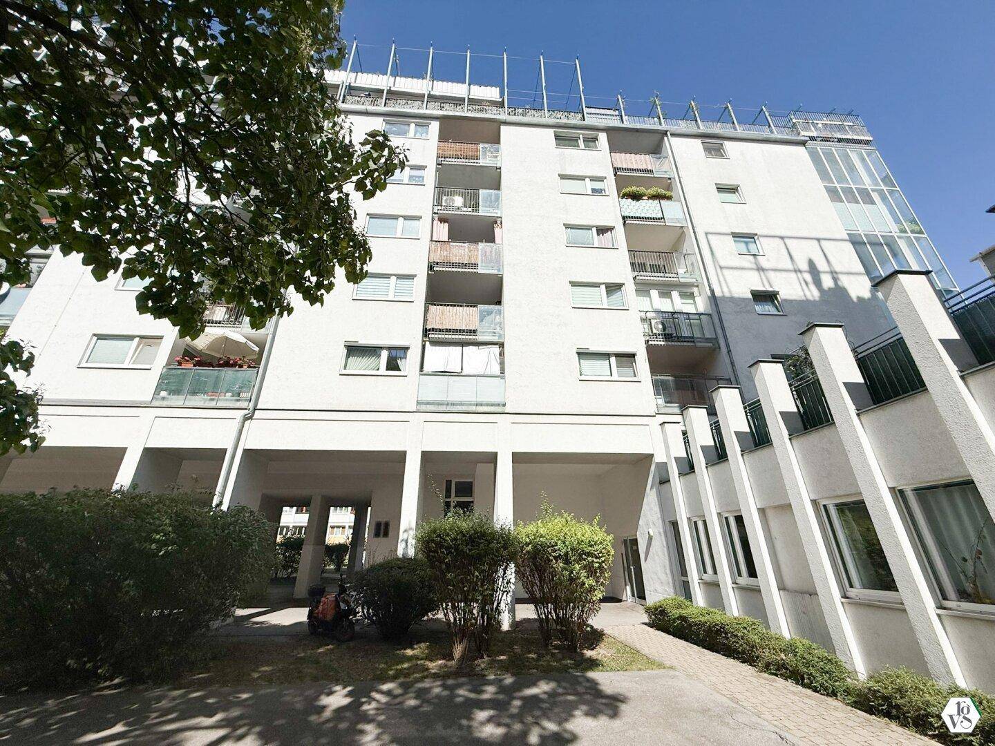 Moderne Fassade eines Wohngebäudes mit zahlreichen Balkonen und großen Fensterfronten.