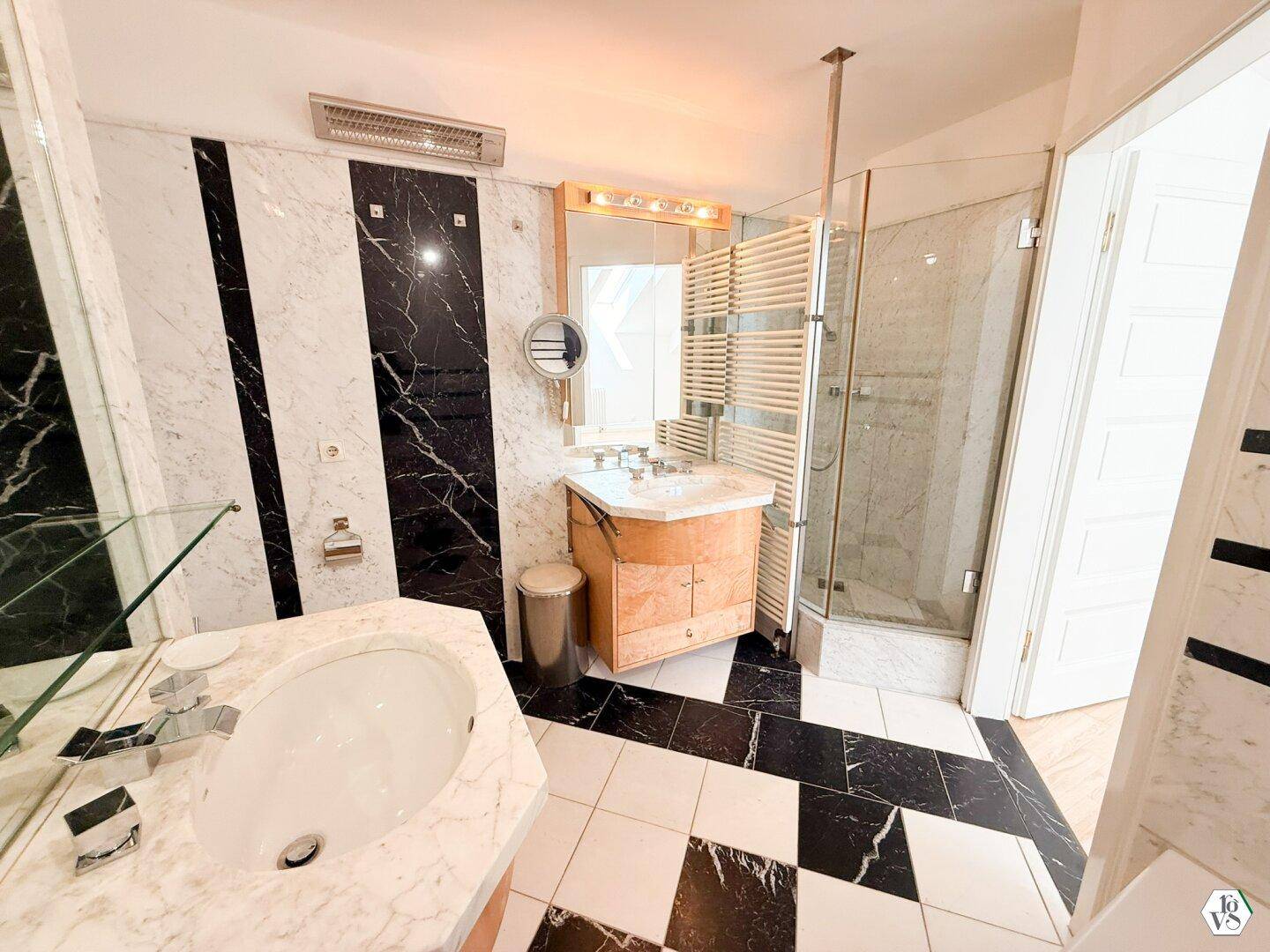 Luxuriöses Badezimmer mit schwarz-weißem Marmor, Doppelwaschbecken und einer modernen Duschkabine.