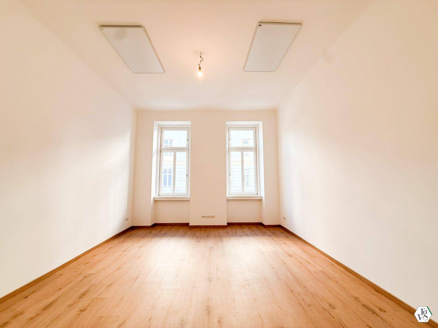 Geräumiger, heller Raum mit zwei Deckenleuchten und Laminatboden, bereit zur individuellen Gestaltung.