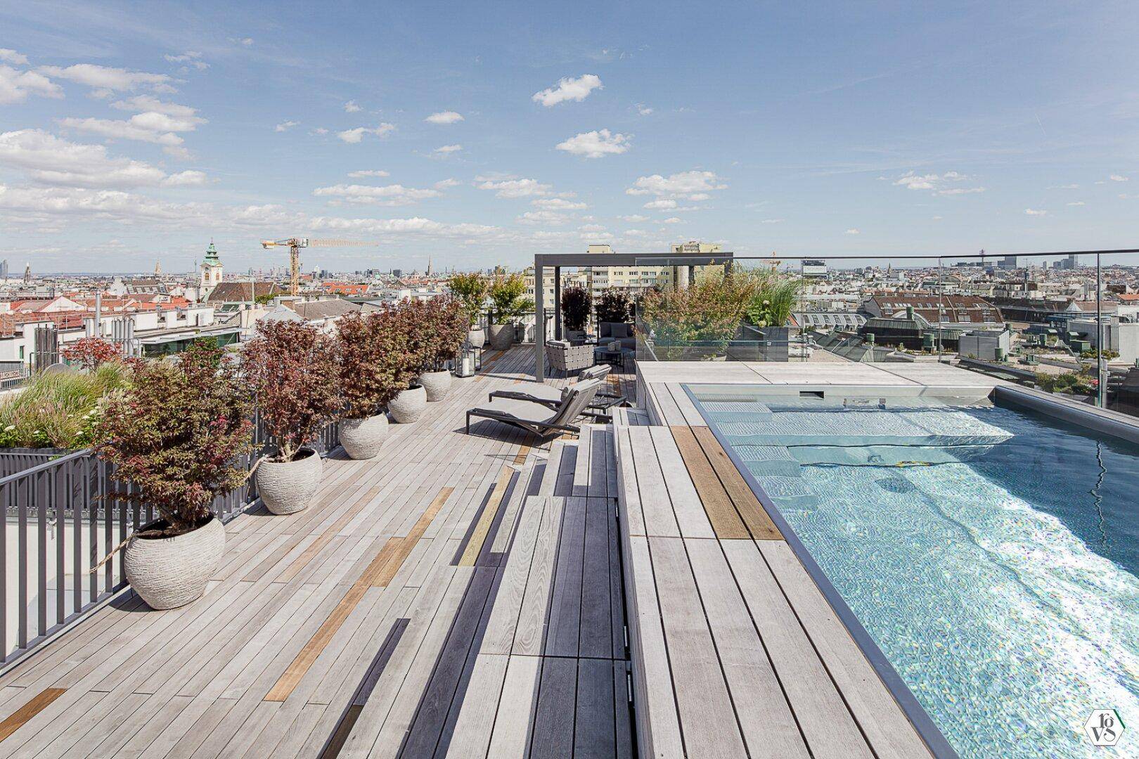 Weitläufige Dachterrasse mit Pool, Liegestühlen und Pflanzen in Töpfen.