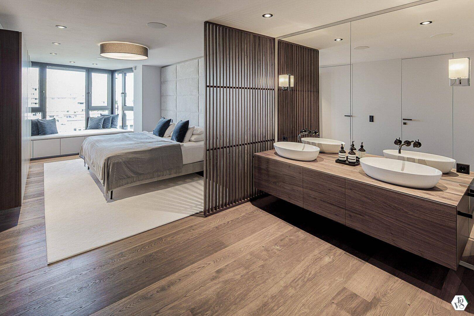 Schlafzimmer mit Holzboden, großem Fenster und integriertem Doppelwaschbecken.