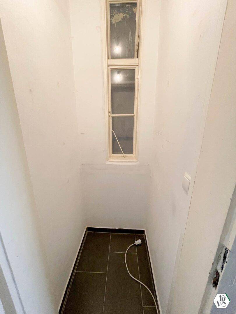 Kleiner Abstellraum mit Fliesenboden und einem schmalen Fenster, ideal für zusätzlichen Stauraum.