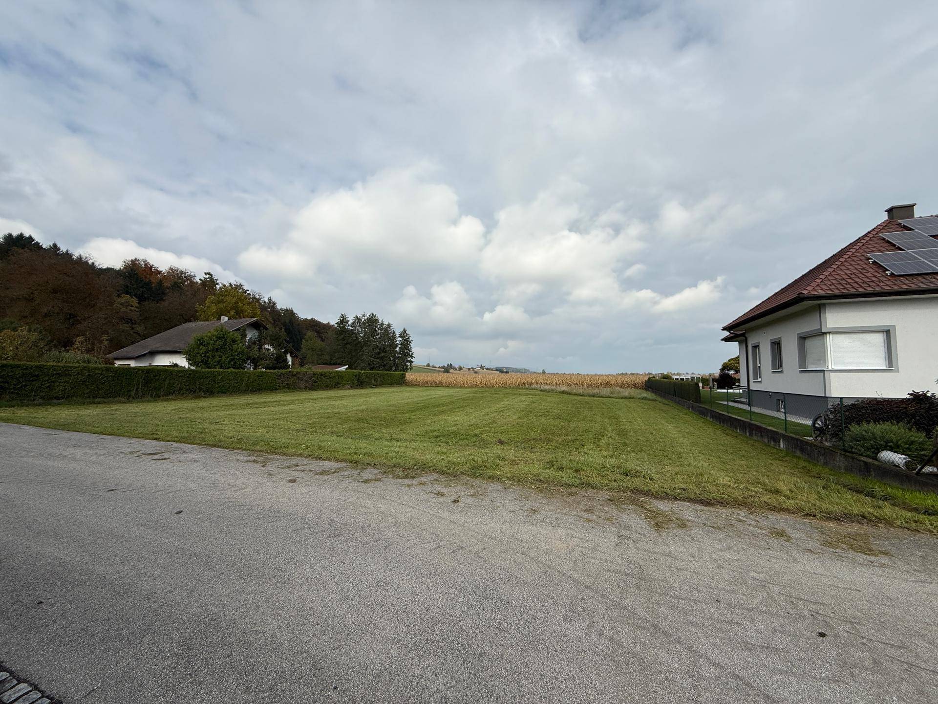 Weitläufiges Grundstück mit gepflegtem Rasen und einem Haus mit Solaranlage am rechten Bildrand.