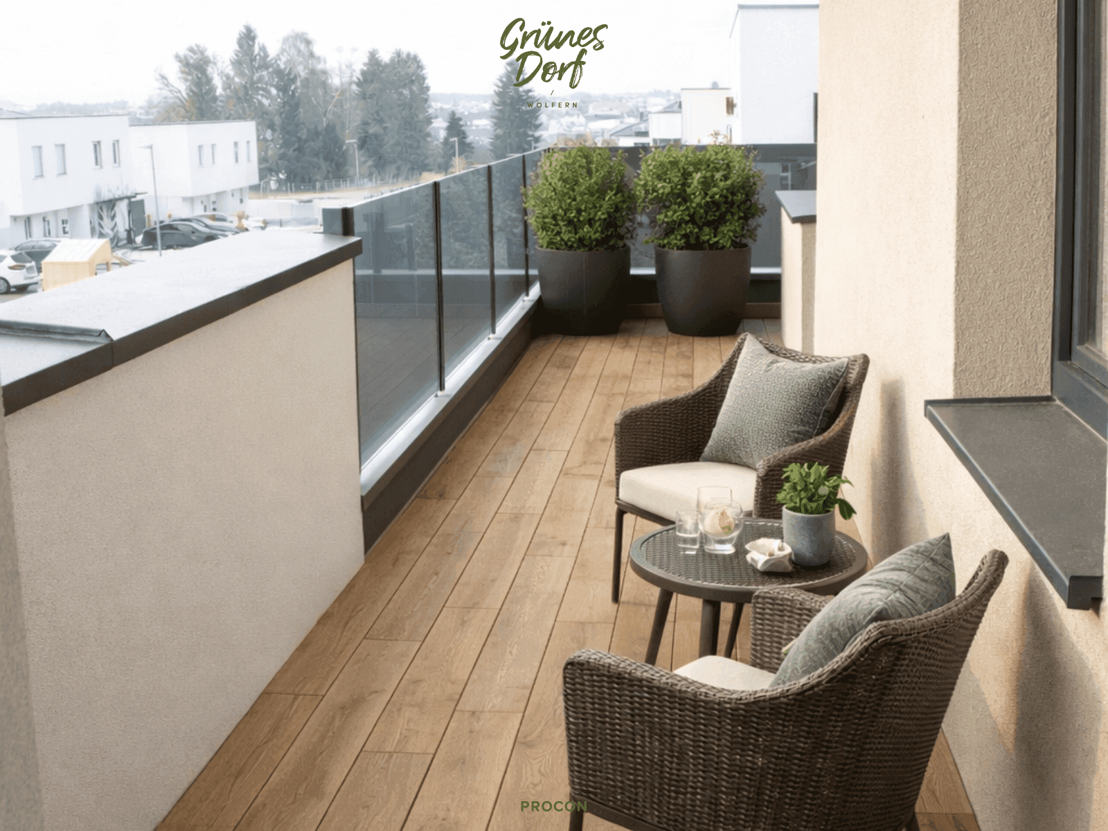 Gemütlicher Balkon mit Holzboden, Glasgeländer und Sitzgelegenheiten für entspannte Momente.