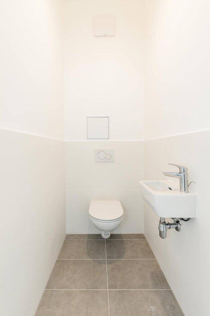 Kleines, modernes Gäste-WC mit wandhängendem WC und kompaktem Waschbecken.