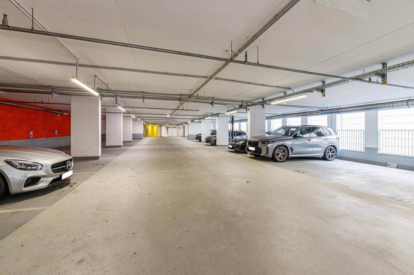 Geräumige Tiefgarage mit mehreren Stellplätzen, Betonpfeilern und guter Beleuchtung.