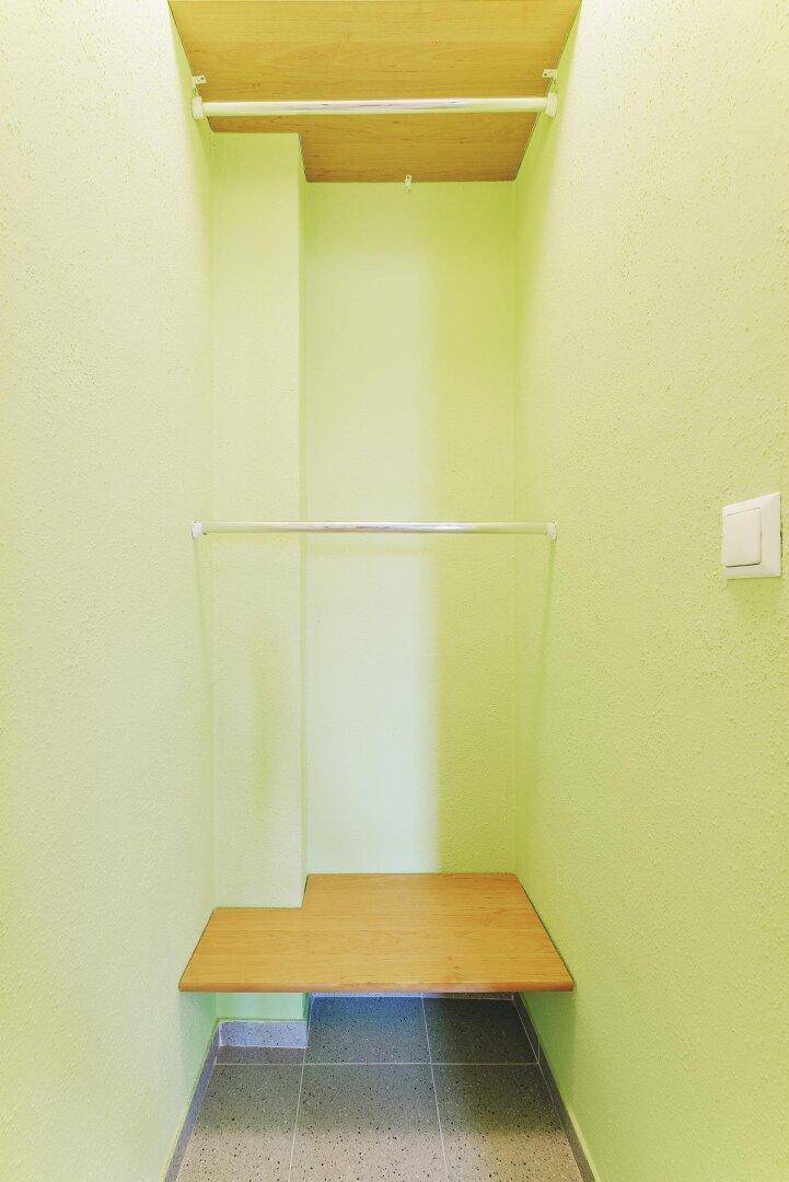 Praktischer Abstellraum mit Regalen und Kleiderstange, ideal für zusätzlichen Stauraum.