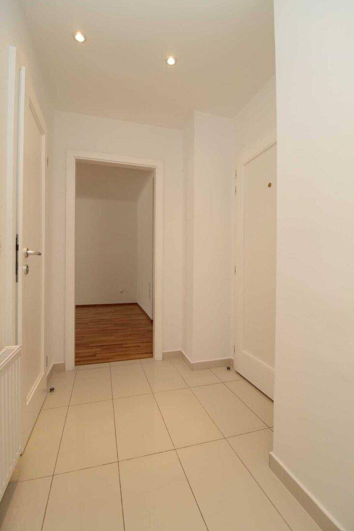 Geräumiger Flur mit Fliesenboden und Einbaustrahlern, verbindet die Wohnbereiche der Wohnung.