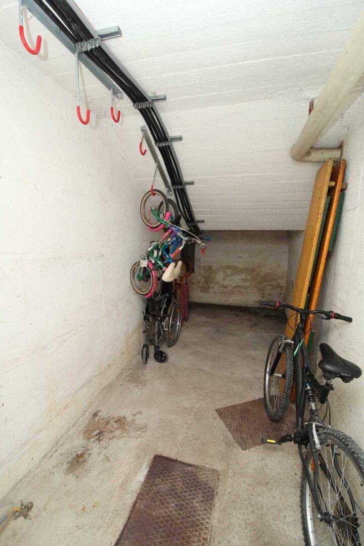 Fahrradraum im Keller mit praktischen Aufhängungen, bietet sichere Abstellmöglichkeiten für Fahrräder.