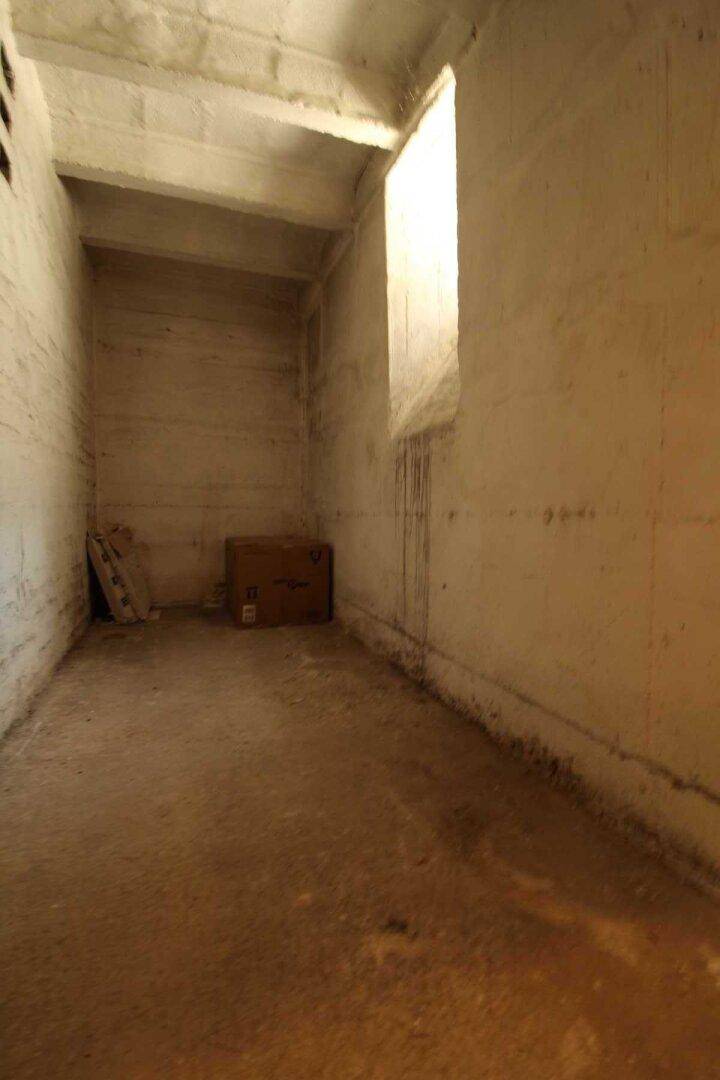 Unausgebauter Kellerraum mit Betonwänden und -boden, bietet zusätzlichen Stauraum für Bewohner.