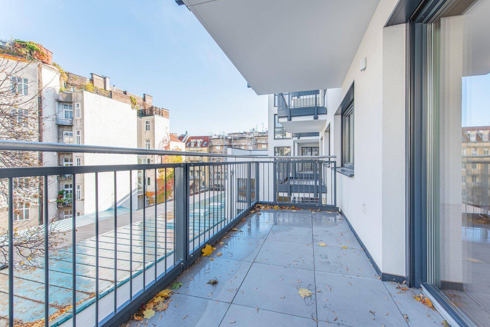 Geräumiger Balkon mit modernem Geländer und Blick auf die Stadtlandschaft.