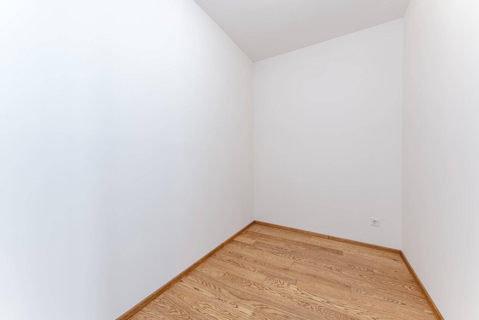 Kleiner, heller Raum mit Parkettboden, ideal als Abstellraum oder Garderobe.