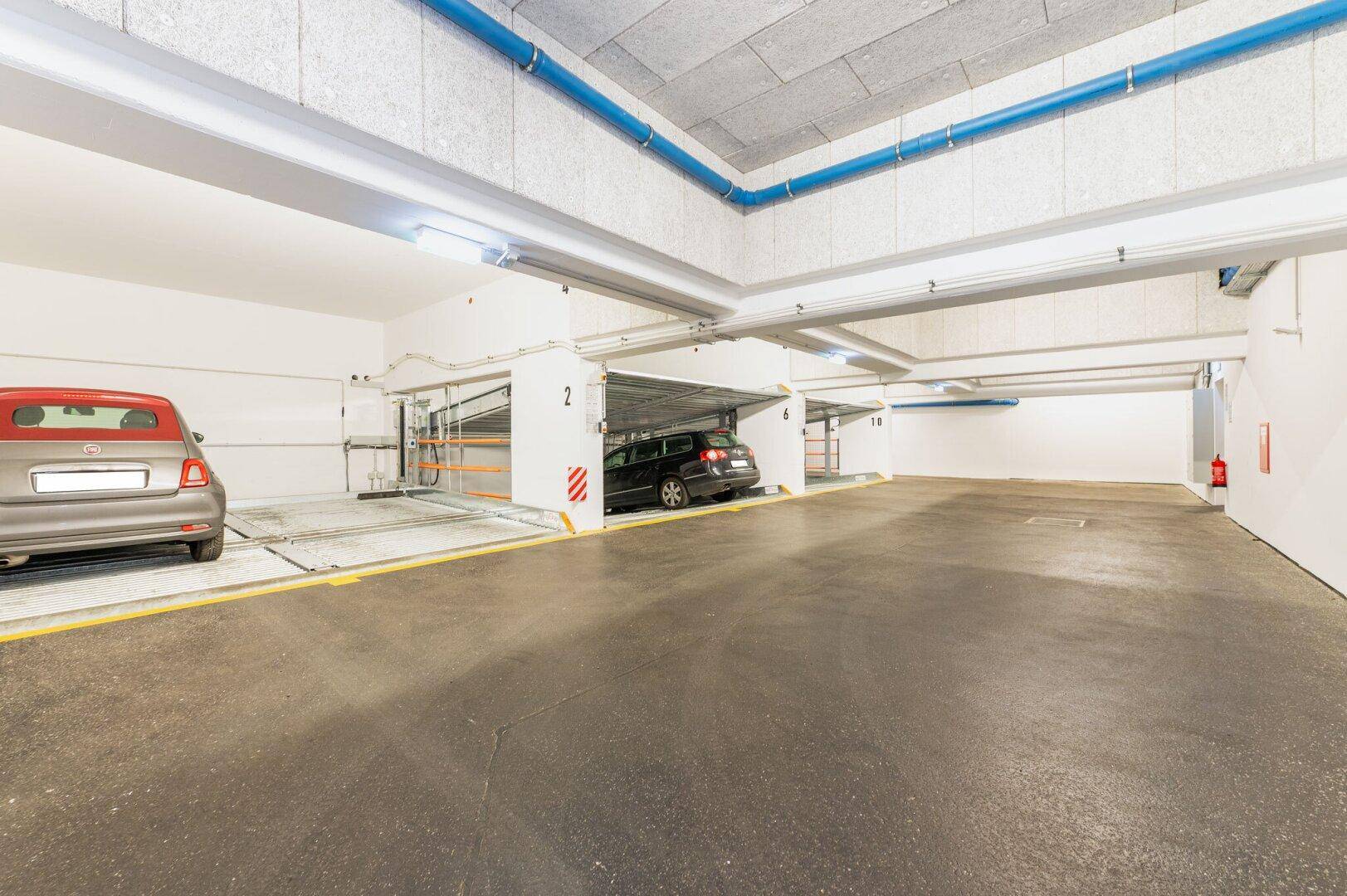 Tiefgarage mit modernen Doppelparkern und ausreichend Platz für Fahrzeuge.