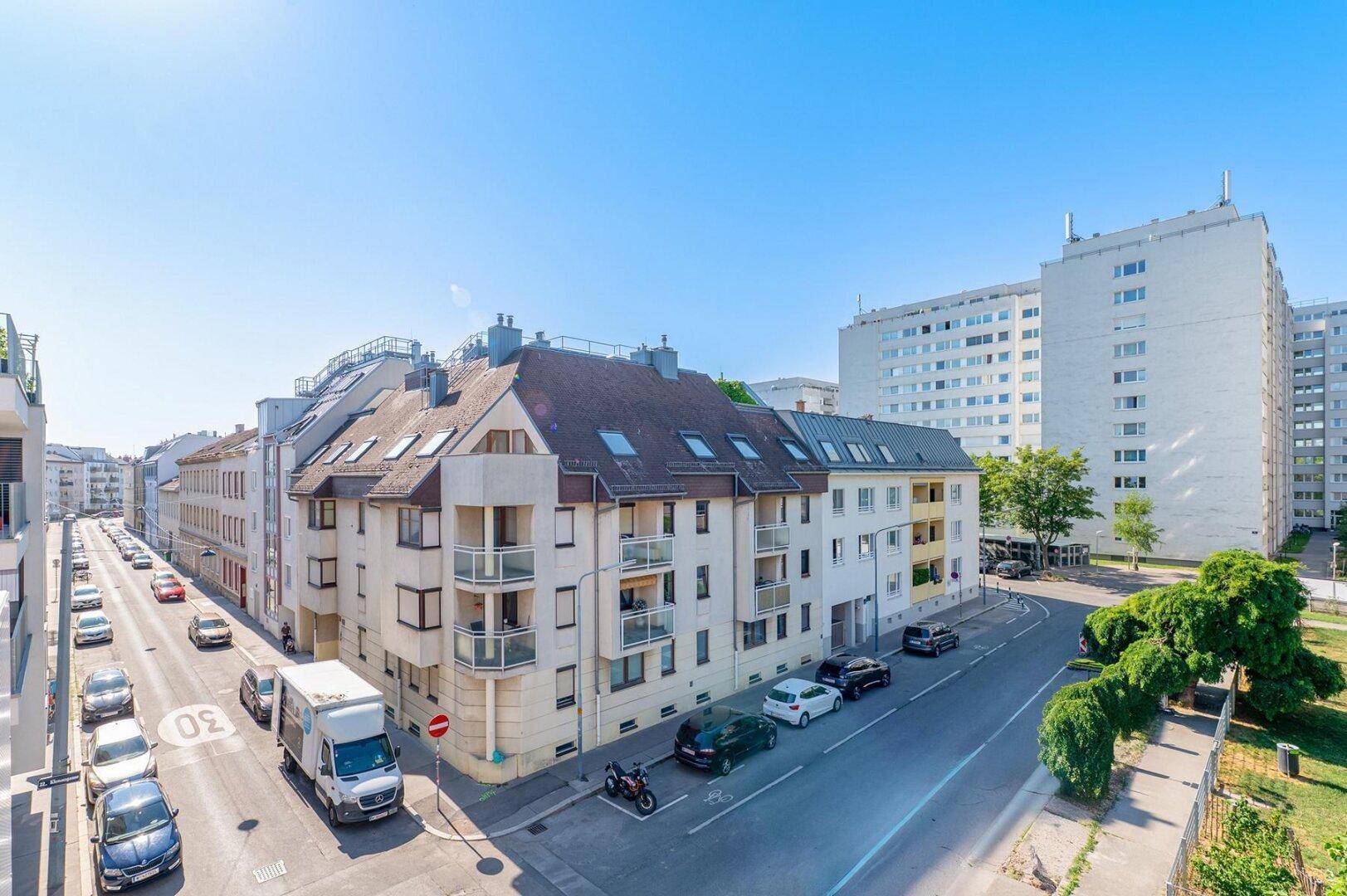 Blick auf eine städtische Straße mit einer Mischung aus traditionellen und modernen Wohngebäuden.