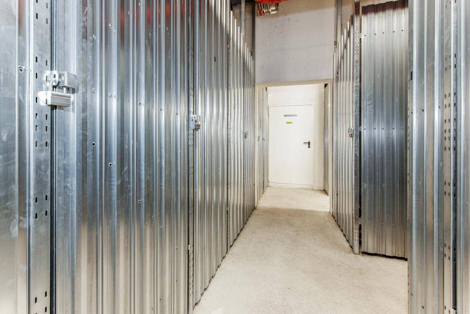 Geräumiger Abstellraum mit Metallwänden und Betonboden, ideal für zusätzlichen Stauraum.