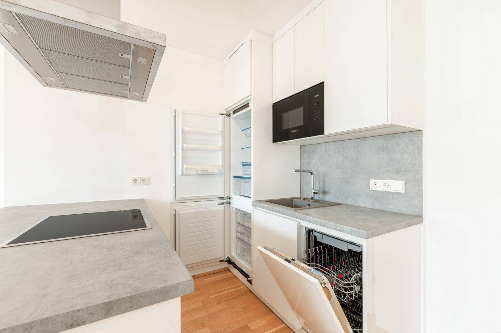 Voll ausgestattete moderne Küche mit integriertem Kühlschrank und Geschirrspüler.