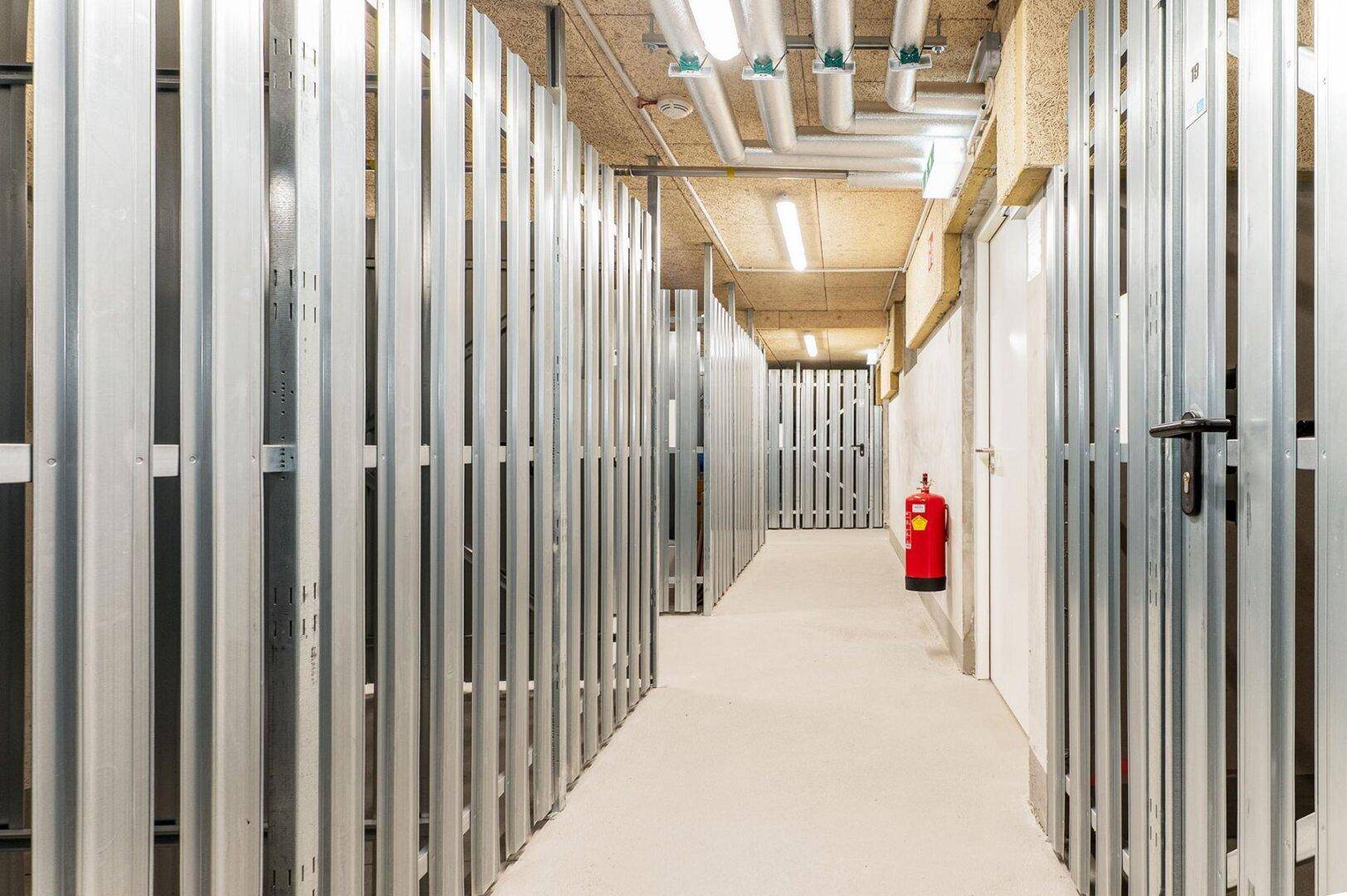 Kellerabteil mit individuellen Stauräumen und Brandschutzvorrichtungen in einem modernen Gebäude.