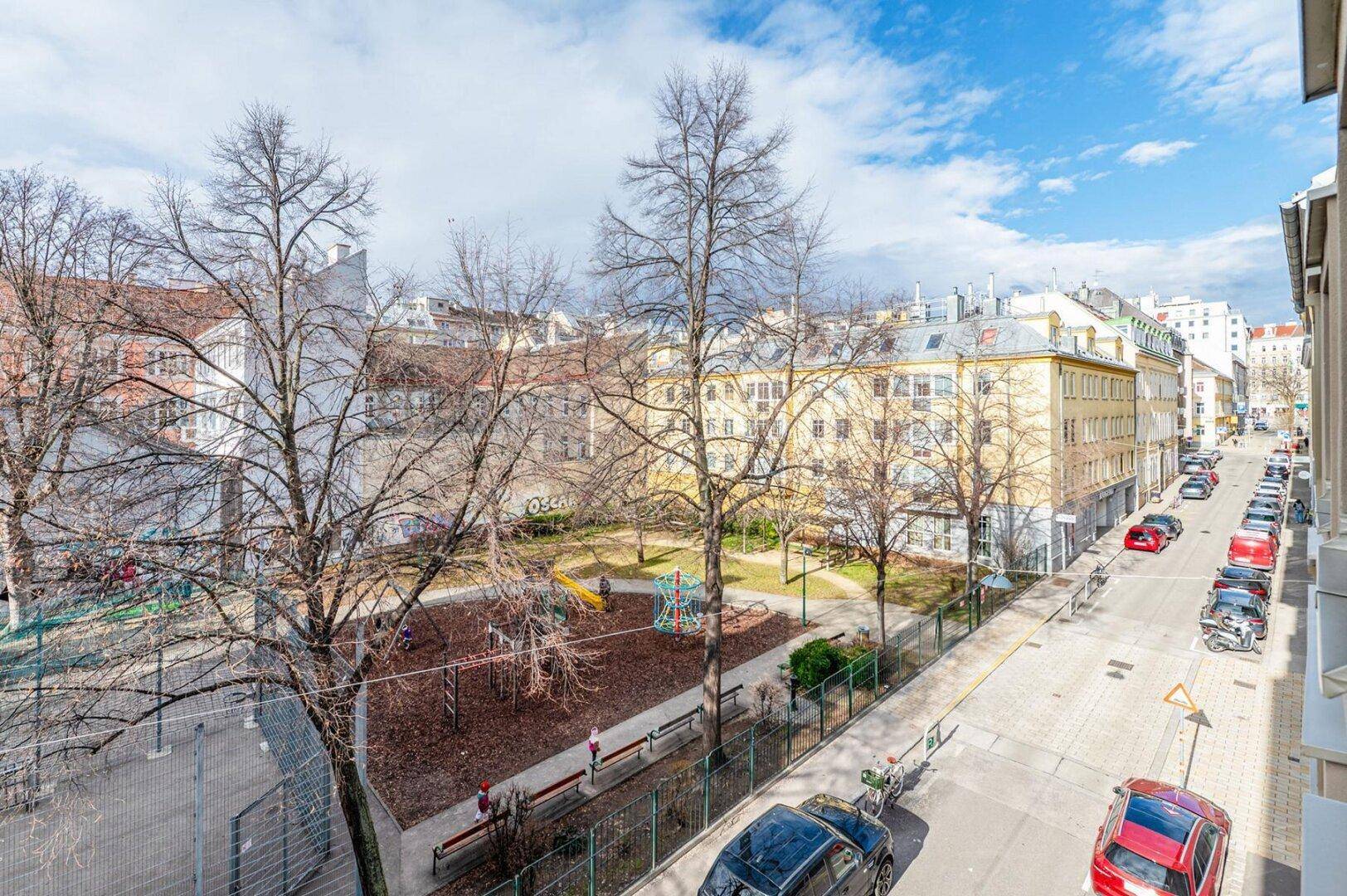 Blick von oben auf einen städtischen Spielplatz und die umliegenden Wohngebäude.