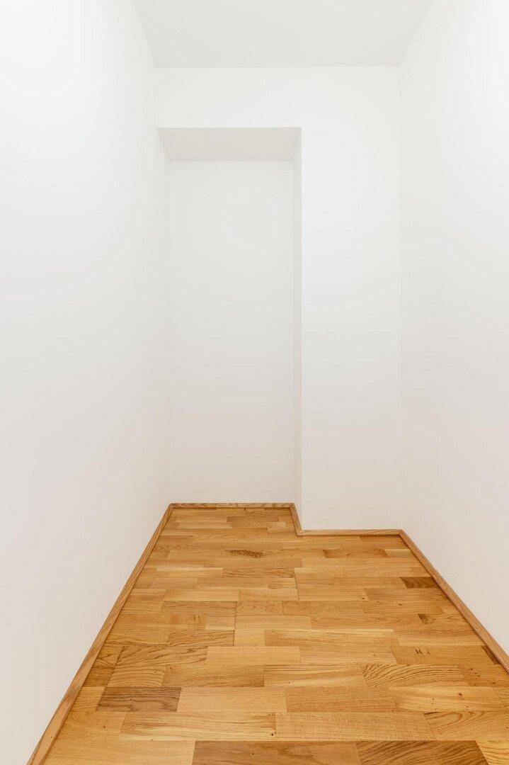 Kleiner Abstellraum mit hellem Parkettboden und weißen Wänden, ideal für zusätzlichen Stauraum.
