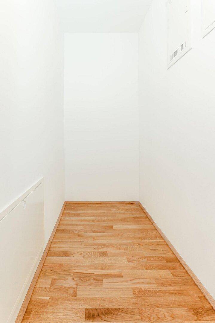 Praktischer Abstellraum mit Parkettboden und weißen Wänden, ideal für zusätzlichen Stauraum.