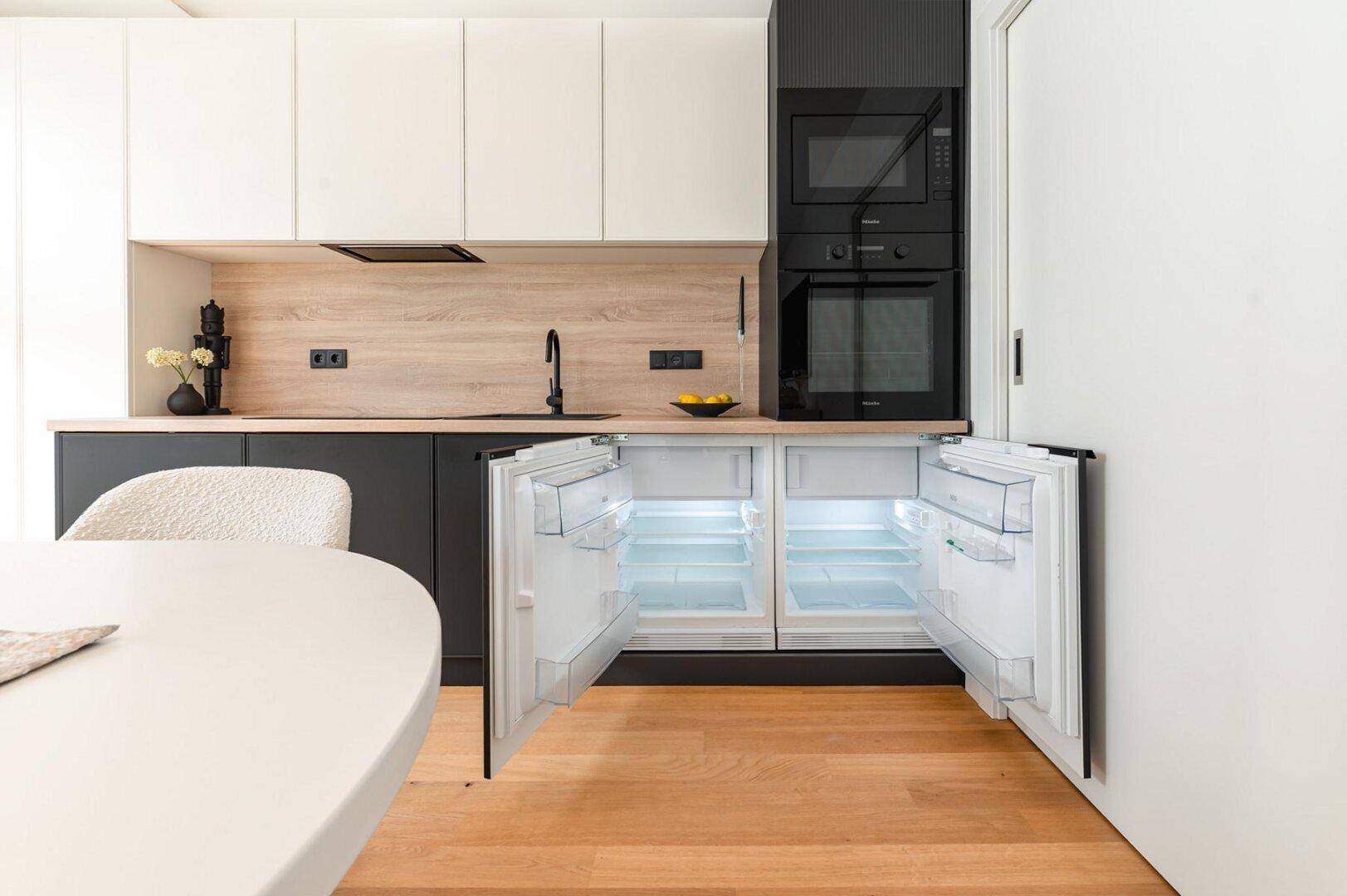 Integrierter Kühlschrank und Gefrierschrank in der modernen Küche mit Holzboden.
