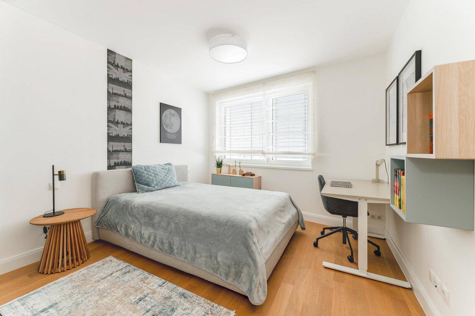 Modernes Schlafzimmer mit Einzelbett, Schreibtisch und Holzboden, hell und funktional.