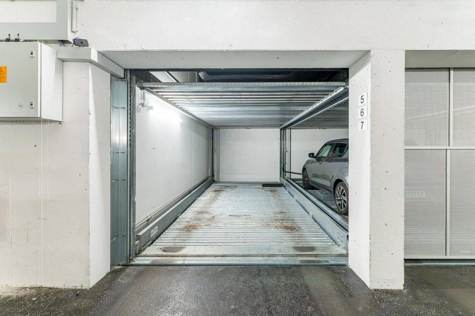Automatisches Parksystem mit einem geparkten Auto in einer modernen Tiefgarage.