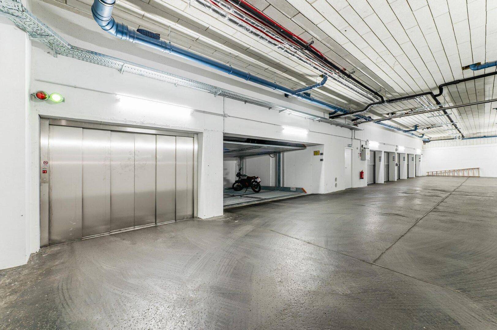Geräumige Tiefgarage mit Aufzug und mehreren Parkplätzen.