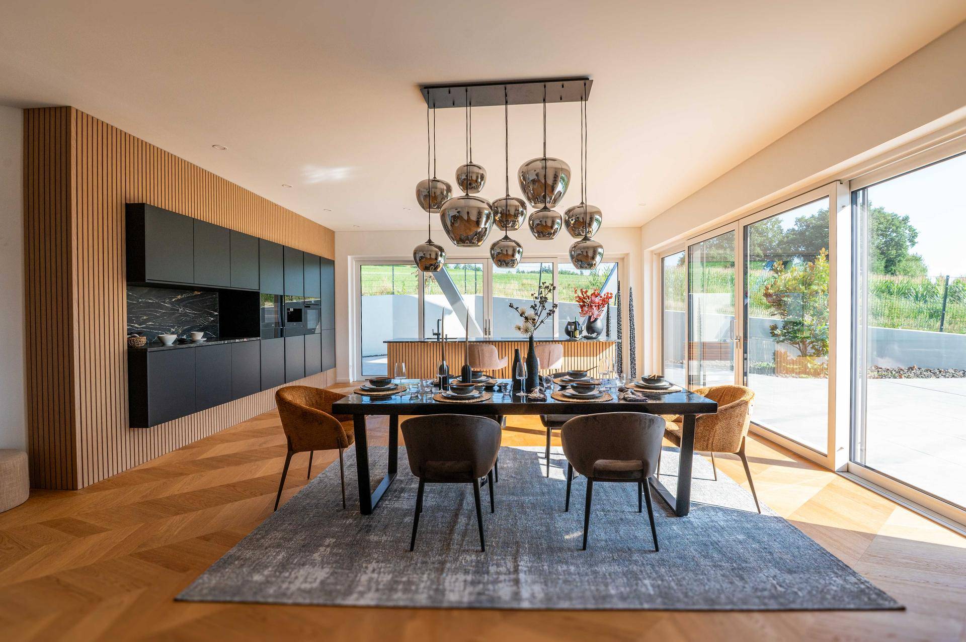 Großzügiger Wohn-Essbereich mit offener Küche, Holzboden und viel Tageslicht.
