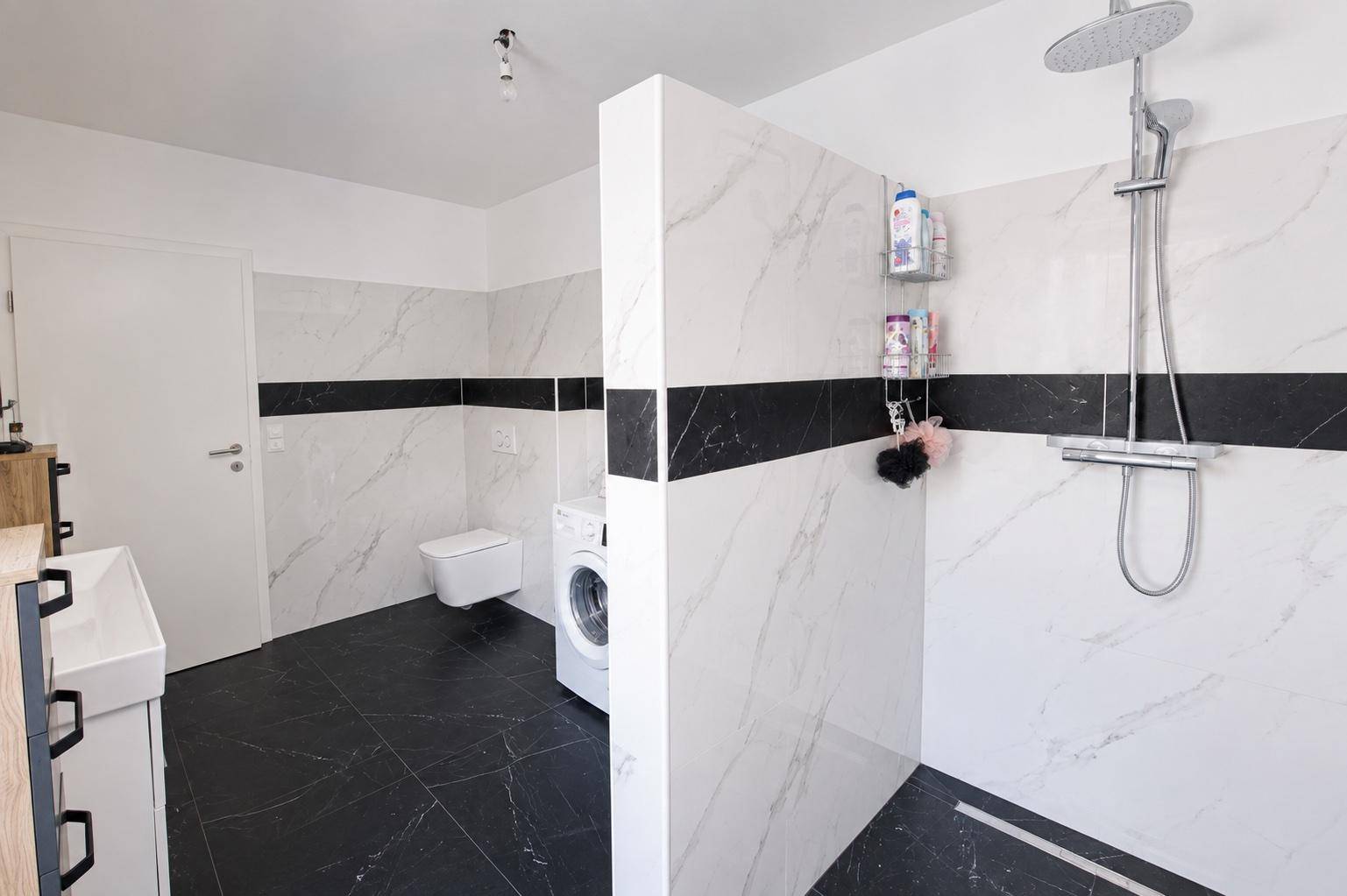 Geräumiges Badezimmer mit begehbarer Dusche, Wand-WC und modernen Fliesen.